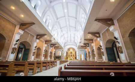 Innenraum innerhalb der Katholischen Kirche in den Philippinen. Gemeindemitglieder und Touristen in der Nähe der Weihnachten Krippe. Gebete. Ausflüge in die Umgebung. Stockfoto