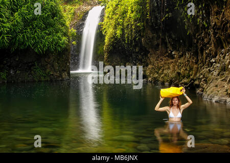 Junge Frau zu Fuß durch Lagune mit einem trockenen Tasche am Wainibau Wasserfall auf Taveuni Island, Fidschi. Taveuni ist die drittgrößte Insel in Fidschi. Stockfoto