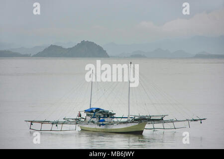 Traditionellen Auslegerboot verankert in Labuan Bajo Stadt auf der Insel Flores, Nusa Tenggara, Indonesien. Mittelpunkt ist die lokale Wirtschaft in der Stadt t Stockfoto