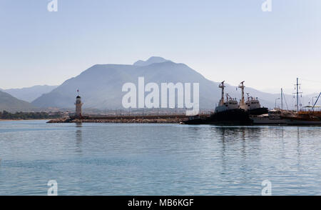 Port mit einem Leuchtturm und Schiffe vor der Kulisse der Berge. Türkei Alanya. Stockfoto