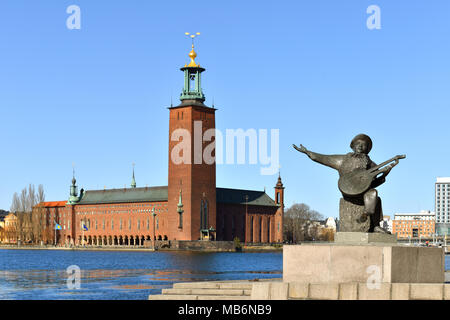 Evert Taube Denkmal auf dem Hintergrund der Stockholmer Rathaus (1923), Gebäude der Gemeinderat der Stadt Stockholm Stockfoto