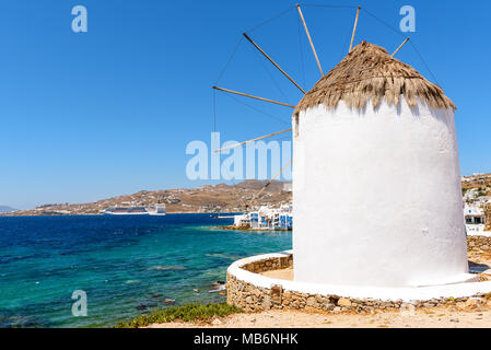 Weißgetünchte traditionelle Windmühle mit Blick auf den Hafen von Mykonos. Insel Mykonos, Kykladen, Griechenland Stockfoto