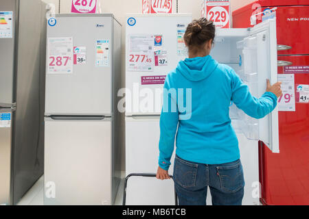 Frau an der neuen Kühlschrank / Kühlschränke/Gefrierkombinationen in elektrischen Store suchen Stockfoto