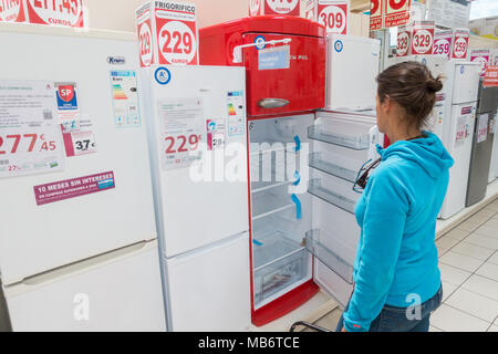 Frau an der neuen Kühlschrank / Kühlschränke/Gefrierkombinationen in elektrischen Store suchen Stockfoto