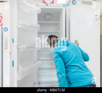 Frau an der neuen Kühlschrank / Kühlschränke/Gefrierkombinationen in elektrischen Store suchen Stockfoto