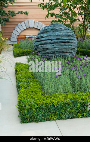 Ursprünglichen kugelförmigen Stein Mittelstück Skulptur, Pfad & Heilpflanzen - "Die Ruhe" Garten, RHS Flower Show, Tatton Park, England, UK. Stockfoto