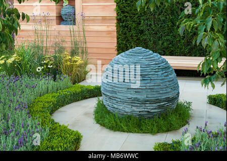 Ursprünglichen kugelförmigen Stein Mittelstück Skulptur, Pfad & Heilpflanzen - "Die Ruhe" Garten, RHS Flower Show, Tatton Park, England, UK. Stockfoto