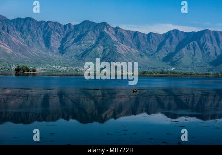 Kaschmir, Indien. 7. April 2018. Reflexion der Zabarwan Hügel über einem der prominenten See in Dal Lake in Srinagar, die Hauptstadt des Indischen verwalteten Kaschmir. Zabarwan Gebirge liegt 32 km lange Sub-Bergkette zwischen Pir Panjal und Great Himalayan Range im zentralen Teil des Kaschmir. Credit: SOPA Images Limited/Alamy leben Nachrichten Stockfoto