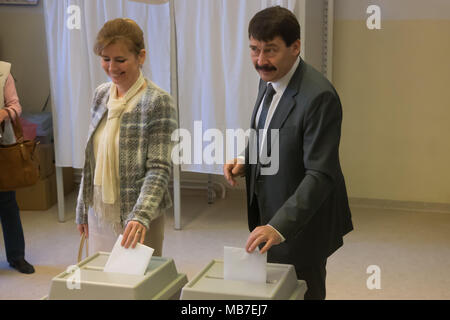 Budapest. 8 Apr, 2018. Ungarns Präsident Janos Ader und seine Frau Anita Herczegh werfen ihre Stimme im Wahllokal in Budapest, Ungarn am 8. April 2018. In Ungarn begann die Parlamentswahlen am Sonntag zu wählen einen 199-Sitz des Europäischen Parlaments. Dadurch könnte der derzeitige Premierminister Viktor Orban in einem dritten geraden langfristig erfolgreich zu sein. Credit: Attila Volgyi/Xinhua/Alamy leben Nachrichten Stockfoto