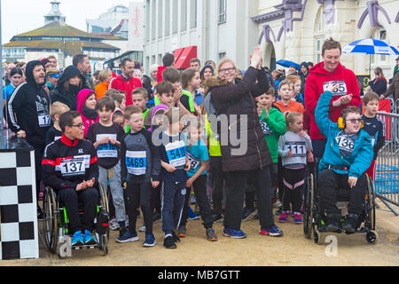 Bournemouth, Dorset, Vereinigtes Königreich, 8. April 2018. Läufer nehmen 36. am Bournemouth Bay Run zum Thema „Superhelden“ Teil, der die Option eines Halbmarathons, 10k Laufs, 5k Laufs und 1k Familienspaß-Laufs entlang der Küste von Bournemouth bietet. Nasses Regenwetter schreckt die Geister der Teilnehmer nicht ab - Kinder und Familien warten auf den Start des Gutscheins über 1k: Carolyn Jenkins/Alamy Live News Stockfoto