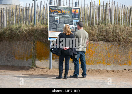 Informationsschild Crosby Marine Park in Merseyside. Die Sonne bricht nach einem grauen Start in den Tag auf dem Mariners Way Küstenweg durch. Urlauber, die die Mersey-Mündungsstrände vor den Toren Liverpools besuchen. Quelle: MediaWorldImages/AlamyLiveNews Stockfoto