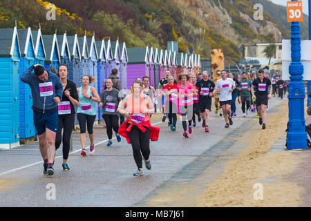 Bournemouth, Dorset, Vereinigtes Königreich, 8. April 2018. Läufer nehmen 36. am Bournemouth Bay Run zum Thema „Superhelden“ Teil, der die Option eines Halbmarathons, 10k Laufs, 5k Laufs und 1k Familienspaß-Laufs entlang der Küste von Bournemouth bietet. Nasses Regenwetter schreckt die Geister der Teilnehmer nicht ab Stockfoto