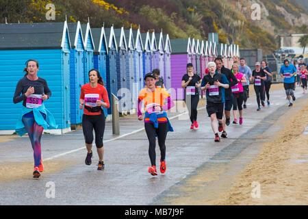 Bournemouth, Dorset, Vereinigtes Königreich, 8. April 2018. Läufer nehmen 36. am Bournemouth Bay Run zum Thema „Superhelden“ Teil, der die Option eines Halbmarathons, 10k Laufs, 5k Laufs und 1k Familienspaß-Laufs entlang der Küste von Bournemouth bietet. Nasses Regenwetter schreckt die Geister der Teilnehmer nicht ab Stockfoto