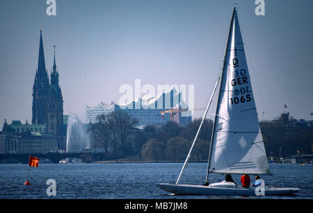 08 April 2018, Deutschland, Hamburg: ein Segelboot auf der Außenalster bei sonnigem Wetter. Die Elbphilharmonie kann im Hintergrund gesehen werden. Foto: Axel Heimken/dpa Stockfoto