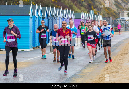 Bournemouth, Dorset, Vereinigtes Königreich, 8. April 2018. Läufer nehmen 36. am Bournemouth Bay Run zum Thema „Superhelden“ Teil, der die Option eines Halbmarathons, 10k Laufs, 5k Laufs und 1k Familienspaß-Laufs entlang der Küste von Bournemouth bietet. Nasses Regenwetter schreckt die Geister der Teilnehmer nicht ab Stockfoto