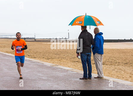 Bournemouth, Dorset, Vereinigtes Königreich, 8. April 2018. Läufer nehmen 36. am Bournemouth Bay Run zum Thema „Superhelden“ Teil, der die Option eines Halbmarathons, 10k Laufs, 5k Laufs und 1k Familienspaß-Laufs entlang der Küste von Bournemouth bietet. Nasses Regenwetter schreckt die Geister der Teilnehmer nicht ab Stockfoto