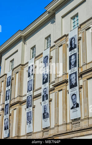 Warschau, Polen - 8. April 2018: Bürogebäude im Zentrum der polnischen Hauptstadt mit Porträts der Opfer des Smolensk-Absturzes. Stockfoto