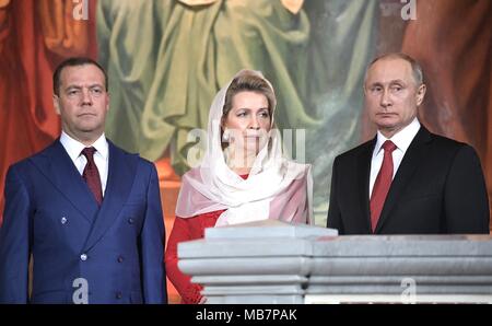 Der russische Präsident Wladimir Putin steht mit der russische Ministerpräsident Dimitri Medwedew, Links, und Swetlana Medwedew, Mitte, während die orthodoxe Ostergottesdienst in der Christ-Erlöser-Kathedrale am 8. April 2017 in Moskau, Russland. Credit: Planetpix/Alamy leben Nachrichten Stockfoto