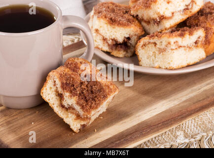 Zimtstange swirl Krümel Kuchen und Kaffee auf einer hölzernen Fach Stockfoto