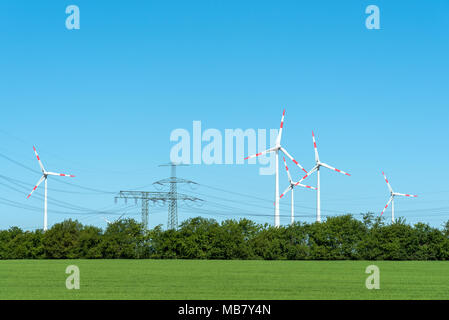 Hochspannungsleitungen und Windkraftanlagen in ländlichen Deutschland gesehen Stockfoto