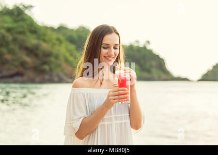 Porträt einer jungen Frau mit einem frische Wassermelone Cocktail auf tropischen Strand Stockfoto