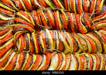 Vegetarische Gericht aus Auberginen, Tomaten und Zucchini, die spiralförmig in einer Mischung von Satay und Ratatouille Stockfoto