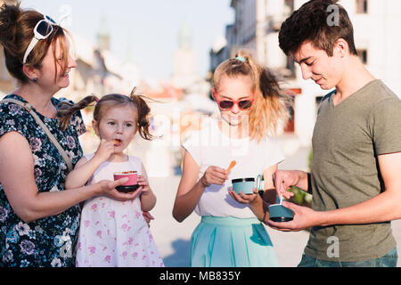 Familie die Zeit, die sie gemeinsam in der Innenstadt genießen Eis essen am Tag. Mutter, Kind und Teenager und junge Ausgaben Stockfoto