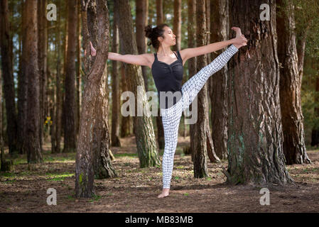 Frau Yoga in einem Wald, verlängerte Hand Zehengriff. Stockfoto