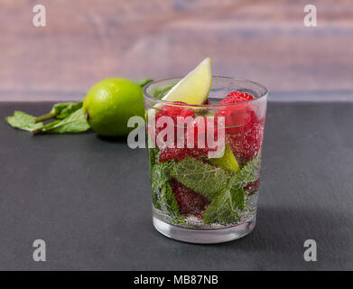 Himbeere Limonade mit Limette und Minze in ein Glas. Nicht-alkoholische Himbeere Erfrischung trinken. Raspberry Mojito in ein Glas mit Minze und Limone. Stockfoto