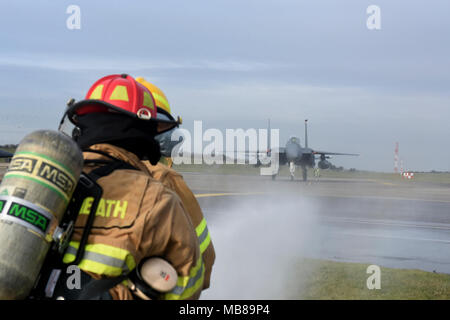 Die Flieger für die 48 Bauingenieur Squadron Zug zugewiesen, während bei F-15E Strike Eagle Taxis durch die Royal Air Force Lakeneheath, England, 8. Februar. RAF Lakenheath Feuerwehrmänner werden geschult, um eine Vielzahl von Notsituationen zu reagieren. (U.S. Air Force Foto/Airman 1st Class Eli Chevalier) Stockfoto