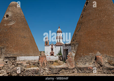 Die Iglesia de San Diego de Alcalá Kirche hinter dem pyramidenförmigen Getreidespeicher in der Hacienda de Jaral de Berrio in Jaral de Berrios, Guanajuato, Mexiko. Die verlassenen Jaral de Berrio Hacienda war einst der größte in Mexiko und beherbergt über 6.000 Personen auf dem Grundstück. Stockfoto