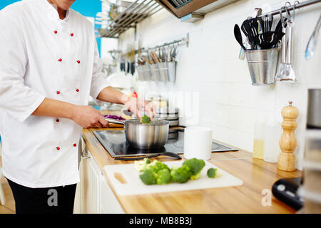 Koch, frischen Brokkoli in Pfanne mit kochendem Wasser beim Kochen Gemüse Eintopf Stockfoto