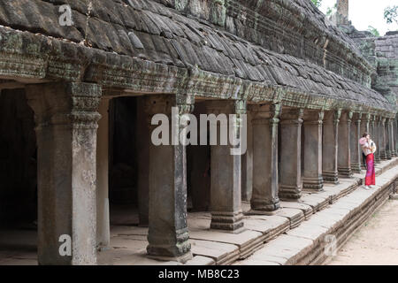 Touristische posiert im Colonnade, Ta Prohm, 12. Jahrhundert ruiniert buddhistischen Tempel, Angkor Ort, Provinz Siem Reap, Kambodscha Asien Stockfoto