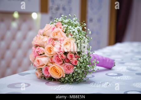 Brautstrauß mit orange und rosa Rosen unterschiedlicher Größe mit auf weißem Hintergrund. Romantische Hochzeit Blumenstrauß mit schönen Blumen. Elegante Stockfoto