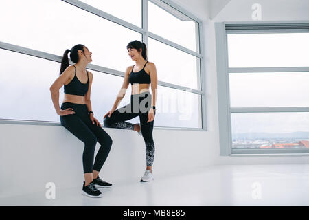 Drinnen geschossen von weiblichen Freunde sprechen, nachdem Fitness Training. Gerne Frauen, die Pause nach dem Training im Fitness Studio. Stockfoto