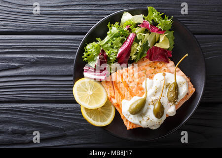 Lachs piccata mit Kapern und Frischer gemischter Salat closeup auf einem Teller. horizontal oben Ansicht von oben Stockfoto
