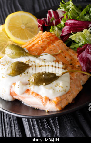 Lachs piccata mit Frischer gemischter Salat closeup auf einem Teller. Vertikale Stockfoto