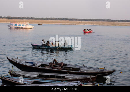 Pilger besuchen die Heilige Stadt und bunten Ruderboote auf den Ganges in Varanasi, Uttar Pradesh, Indien Stockfoto