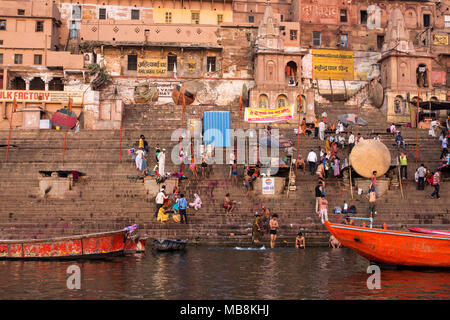 Pilger besuchen die Heilige Stadt und bunten Ruderboote auf den Ganges in Varanasi, Uttar Pradesh, Indien Stockfoto