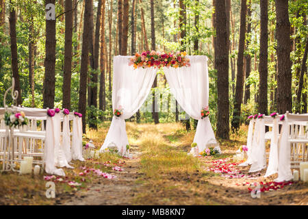 Schöne romantische festliche Ort mit Holz- und Blumen Rosen Dekorationen für außerhalb der Trauung im Green Park gemacht. Hochzeit-Einstellungen an Stockfoto