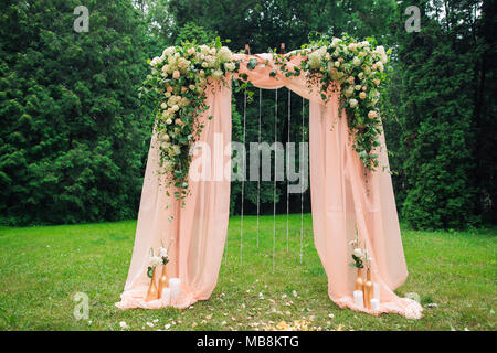 Wunderschöner Ort mit Holz- und Blumen Rosen Dekorationen für außerhalb der Trauung im Green Park gemacht. Hochzeit Einstellungen an der szenischen statt. Hor Stockfoto