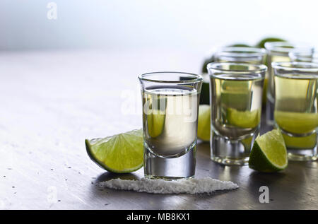 Mexikanische Gold Tequila in kurzen Gläsern mit Kalk und Salz auf alten Holztisch. Exemplar. Stockfoto