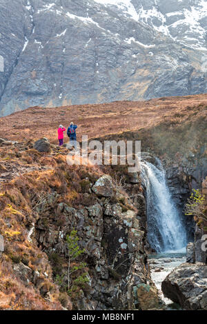 Senior Paar an Black Cuillin und Fairy Pools, Fluss Spröde, Isle of Skye, Schottland, UK im März - Wasserfall Stockfoto