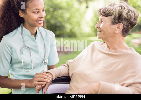 Ältere Frau und ihr Arzt die Zeit im Garten außerhalb des Krankenhauses Stockfoto