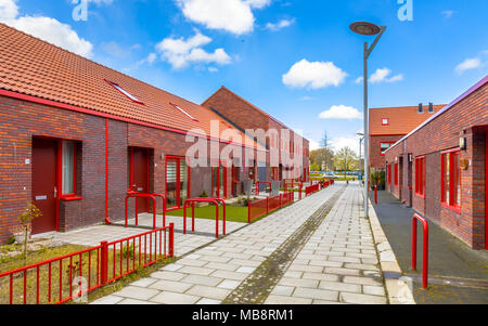 Moderne Gegend mit braunen Backsteinhäusern und roten Elementen. Stockfoto