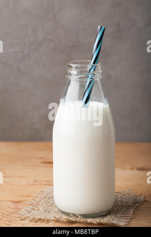 Flasche Milch auf einen hölzernen Tisch über dunklen Hintergrund mit kopieren. Stockfoto