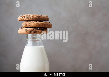 Mit Milch und Chocolate Chip Cookies auf dunklem Hintergrund mit Kopie Raum Flasche. Stockfoto