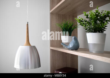 Kronleuchter und Blumen in Töpfe auf hölzernen Regalen Stockfoto