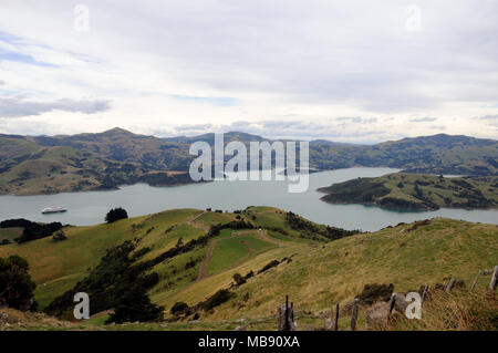 Ausblick hinunter auf einem Kreuzfahrtschiff verankert auf dem Appraoch in die kleine Stadt am Ufer von Akaroa Halbinsel in der Nähe von Christchurch, Neuseeland. Stockfoto