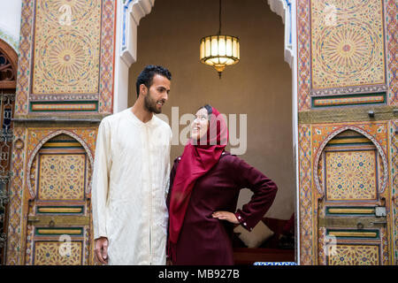 Junge muslimische Paare in Beziehung reden und lächeln im traditionellen marokkanischen Riad Haus Stockfoto